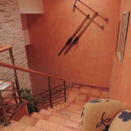 Recibidor con escaleras decorado con un arado en la pared