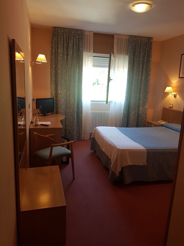 Habitación con cama de matrimonio grande y ventanal